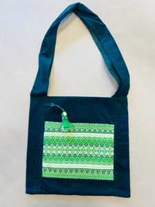 Green corduroy cross body tote with hanging motanka amulet from Bakhmut Creative Workshop
